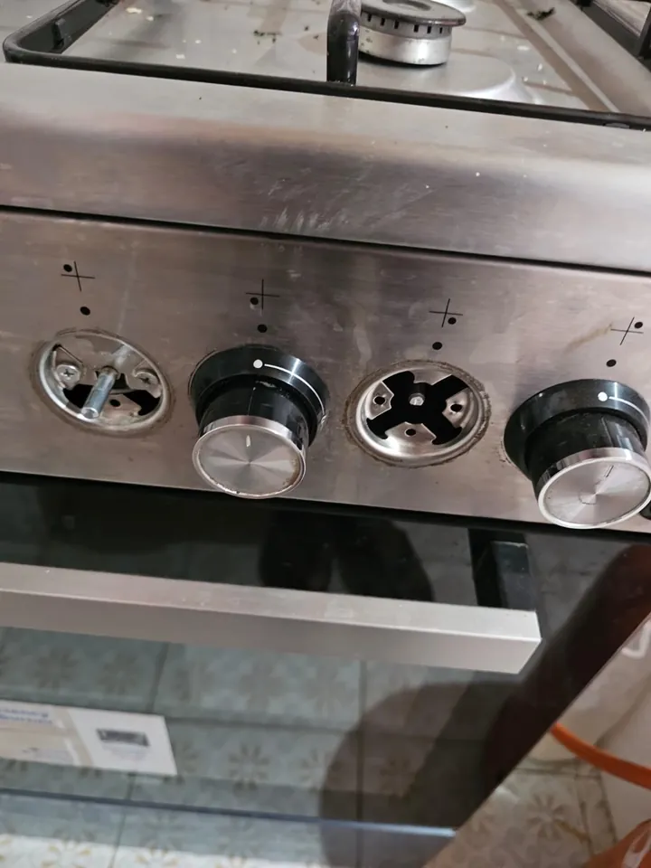 Stainless cooker control panel with the knobs being checked