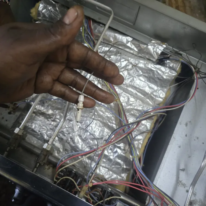 Technician tracing oven wiring under the insulation foil