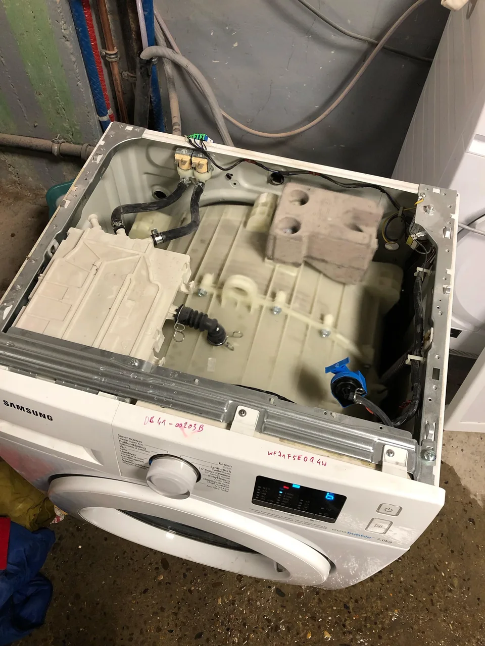Samsung front-load washing machine with the top panel off during a repair